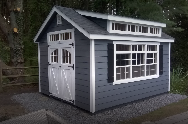 blue shed with white doors, windows, and trim